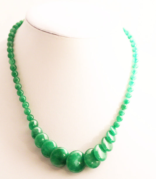 A handmade green jade necklace displayed on a mannequin.