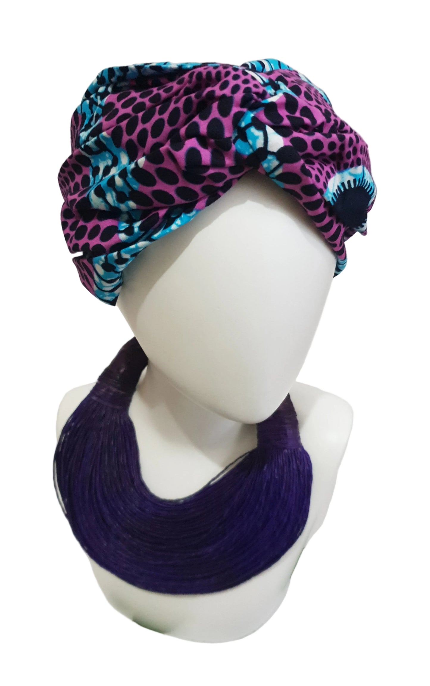A turban style headband in purple and blue print, displayed on a mannequin head.